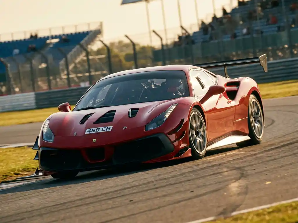 Roter Ferrari 488 Challenge in schneller Kurvenfahrt auf sonnenbeschienem Rennkurs, Hinterräder mit Bewegungsunschärfe, verschwommene Tribünen im Hintergrund.