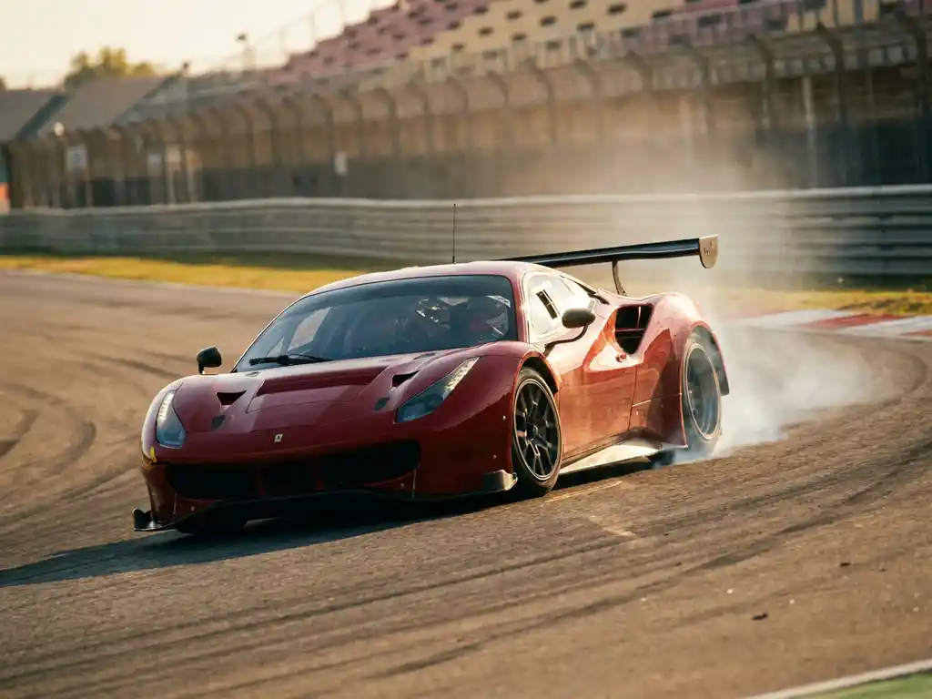 Roter Ferrari-Rennwagen in schneller Kurvenfahrt auf sonnenbeschienem europäischen Rundkurs mit Reifenrauch und Bewegungsunschärfe.